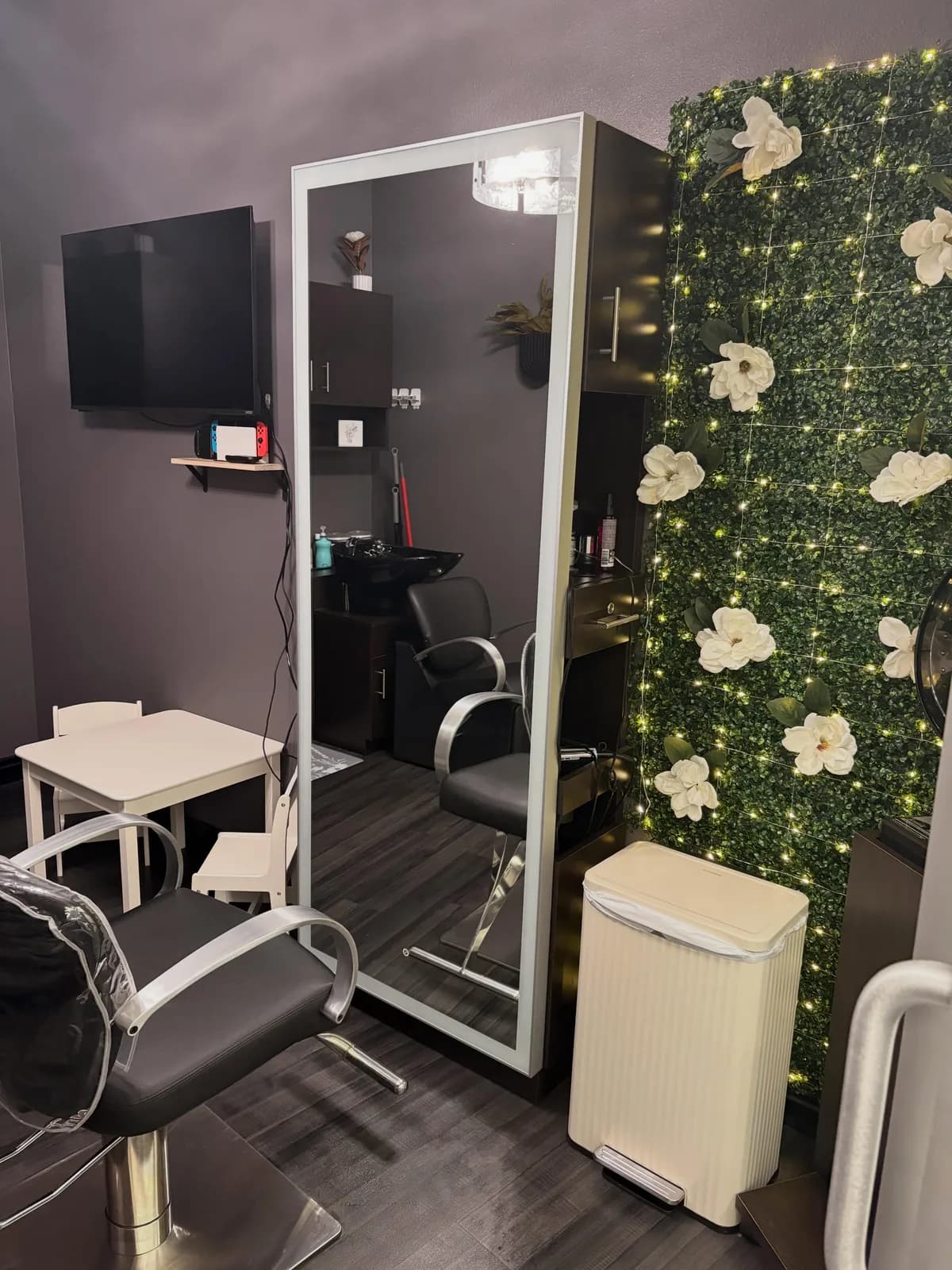 Magnolia Mane styling station with the signature green-and-white magnolia feature wall in Goodyear, AZ