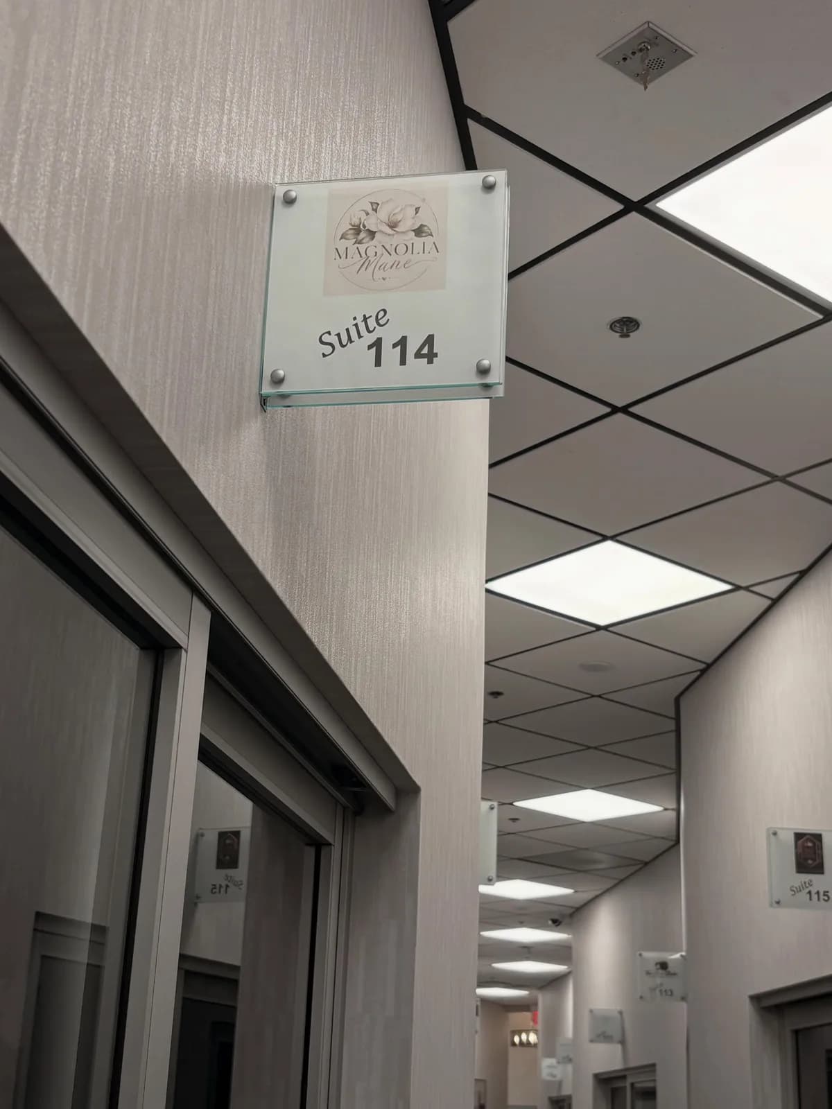 Frosted-glass Suite 114 door sign at the entrance of Magnolia Mane in Goodyear, AZ
